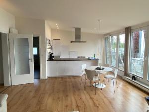 a kitchen and living room with a table and chairs at Seepanorama in Groß Wittensee
