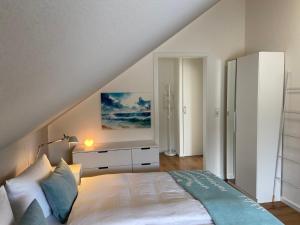 a bedroom with a white bed and a white dresser at Seepanorama in Groß Wittensee