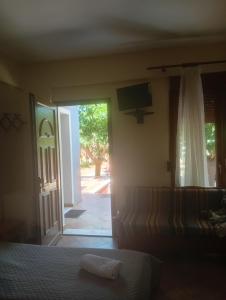 a bedroom with a bed and a door with a television at Evriaki Rooms Lesvos in Gera