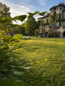 a field of green grass with buildings in the background at Le Relais du Doubs en Bourgogne in Ciel