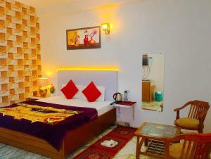a bedroom with a bed and a table and a chair at Solan Regency in Solan