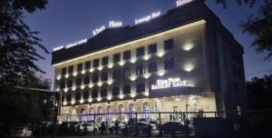 a lit up building with cars parked in front of it at Khan Plaza Hotel in Almaty