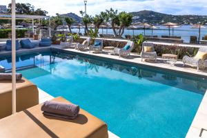 a swimming pool with lounge chairs and a resort at Alidian bay Suites Leros in Alinda