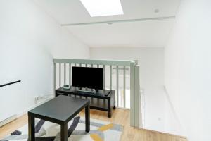 a living room with a table and a tv at Escapade Landaise, Piscine in Capbreton