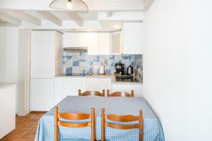 a kitchen with a table with two chairs and a table and a kitchen at Escapade Landaise, Piscine in Capbreton