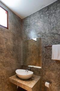 ein Badezimmer mit Waschbecken und Spiegel in der Unterkunft A Hotel Cozy in Chiang Saen + 18 Fotos