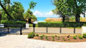 a black fence with a view of the water at Angele Pihenőház in Balatonszárszó
