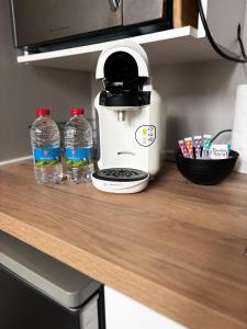 a coffee maker and two bottles of water on a counter at Le Moderne - 2 Voyageurs in Rouen