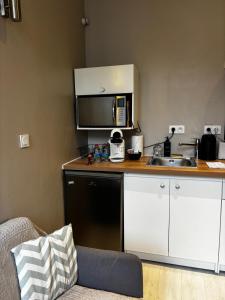 a small kitchen with a sink and a microwave at Le Moderne - 2 Voyageurs in Rouen