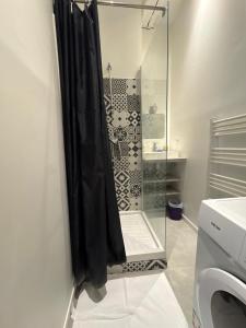 a shower in a bathroom with a black shower curtain at Le Moderne - 2 Voyageurs in Rouen