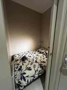 a small bedroom with a bed with a black and white comforter at Le Moderne - 2 Voyageurs in Rouen