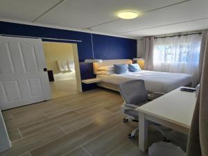 a hotel room with a bed and a desk and a desk at NiNETEEN28 Guesthouse in Pietermaritzburg
