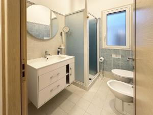 a bathroom with a sink and a toilet and a mirror at Puntabraccetto Sunset in Santa Croce Camerina +67 photos