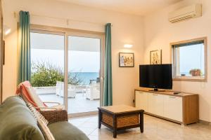 a living room with a couch and a television at Puntabraccetto Sunset in Santa Croce Camerina