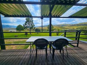 a table and two chairs on a deck with a view at Clarossouw in Clarens