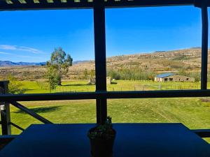 a view of a field from a window with a table at Clarossouw in Clarens