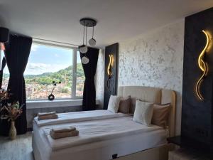 a bedroom with a large bed with a large window at Balkan tower REST 2 Безплатно паркомясто in Gabrovo