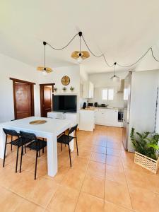 a kitchen and dining room with a white table and chairs at Casa Victoria in Antigua