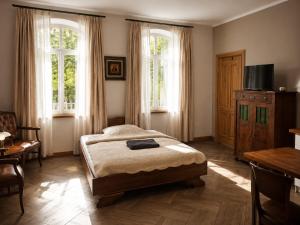 a bedroom with a bed and two windows at Apartamenty Sunny Bear in Jelenia Góra
