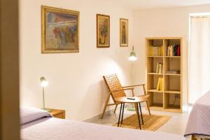 a bedroom with a chair and a book shelf at Puntabraccetto Sunset in Santa Croce Camerina