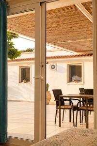 a sliding glass door leading to a patio with a table at Puntabraccetto Sunset in Santa Croce Camerina