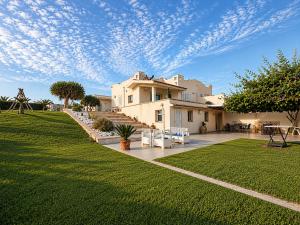 a large house with a grassy yard with a house at Puntabraccetto Sunset in Santa Croce Camerina