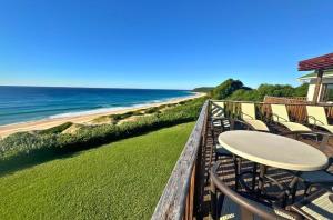 a balcony with chairs and a table and the beach at Kangela 1 in Ponta Malangane
