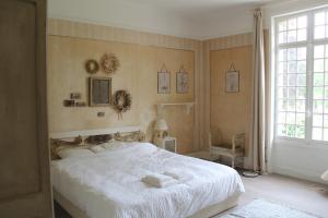 a bedroom with a white bed with towels on it at Le Relais du Doubs en Bourgogne in Ciel +42 photos