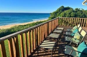 a row of chairs sitting on a balcony overlooking the beach at Kangela 1 in Ponta Malangane