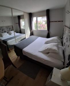 a bedroom with two beds and a mirror at Les Lavandins,Chambre climatisé, à 300 Tram L5, PARKING et WIFI gratuit in Montpellier