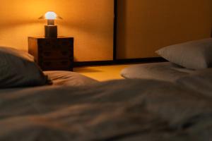 a bedroom with two beds and a lamp on a night stand at 古民家一棟貸 鴨部巣 kamobese in Kochi