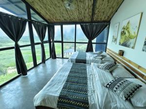 a large bed in a room with large windows at Mây Villa HA in Yên Bài