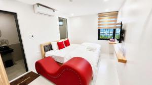 a room with a bed and a red chair at Habibi Hotel in Sóc Sơn