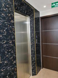 a elevator in a building with a black marble wall at Habibi Hotel in Sóc Sơn