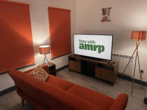 a living room with a couch and a flat screen tv at 1 Bed Apartment Sleeps 3, Ferryhill Near Durham & WiFi in Ferryhill