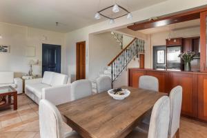 a dining room and living room with a wooden table and chairs at Royal Bay Villa Bali in Bali +43 photos