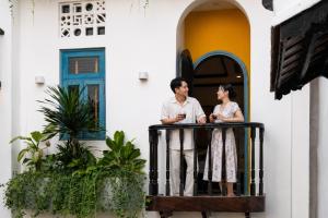 a man and woman standing on the balcony of a house at Yzistel Hoi An in Hoi An