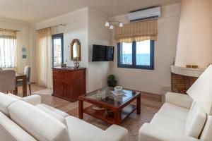 a living room with white furniture and a fireplace at Royal Bay Villa Bali in Bali