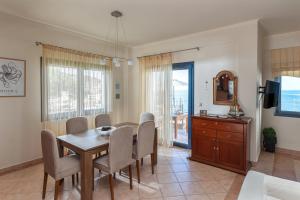 a dining room with a table and chairs and a television at Royal Bay Villa Bali in Bali