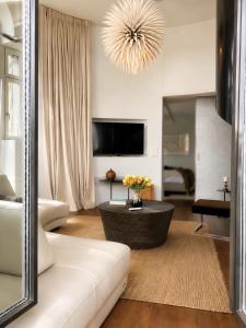 a living room with a couch and a chandelier at The Crown Penthouse Bahnhofstrasse in Zurich +30 photos