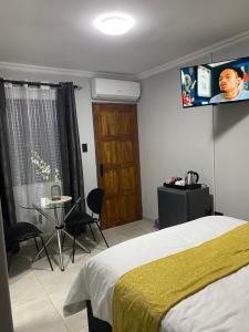 a bedroom with a bed and a tv on the wall at Black Rose Guesthouse Northam in Northam
