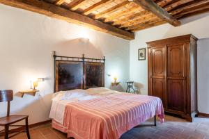 a bedroom with a bed and a wooden cabinet at Appartamento Nobile Murlo in Murlo