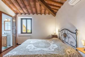 a bedroom with a bed and a window at Appartamento Brunello Murlo in Murlo