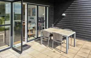 a wooden table and chairs on a patio at 2 Bedroom Nice Apartment In Samsø in Ballen +7 photos