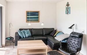 a living room with a black couch and a table at 2 Bedroom Nice Apartment In Samsø in Ballen