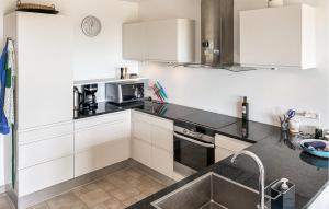 a kitchen with white cabinets and a sink at 2 Bedroom Nice Apartment In Samsø in Ballen