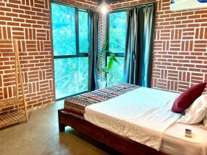 a bedroom with a bed in front of a brick wall at Nang Villa HA in Yên Bài +41 photos