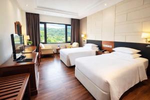 a hotel room with two beds and a television at Sai Gon Ha Long Hotel in Ha Long +16 photos