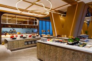 a restaurant with a buffet line with food at Harris Hotel & Convention Serpong in Tangerang
