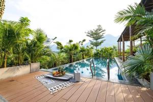 a wooden deck with a table and a laptop on it at Nang Villa HA in Yên Bài